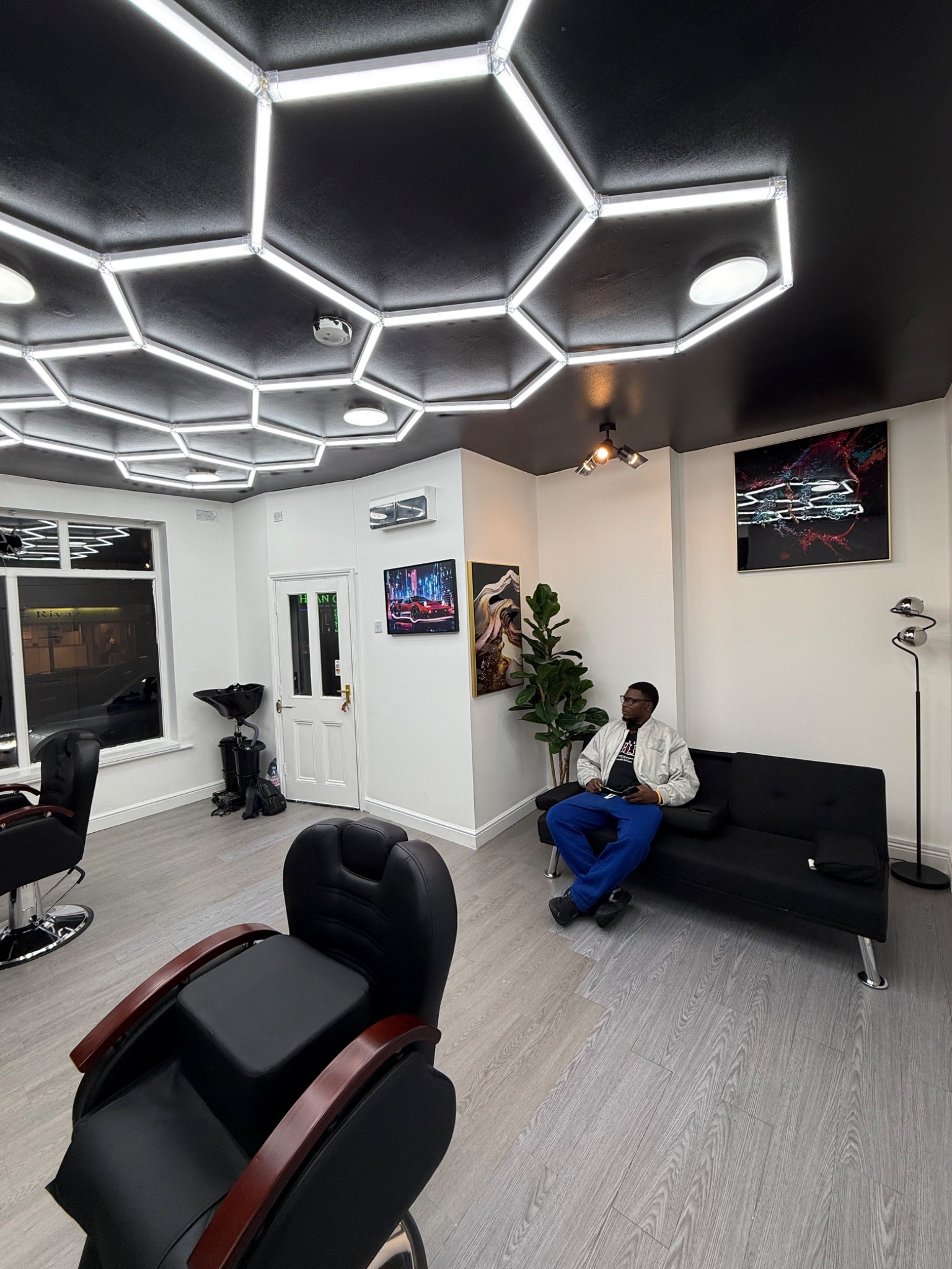 Chris, founder and CEO of MBACUTZ Hair Studio, seated on the sofa in his Lincoln studio