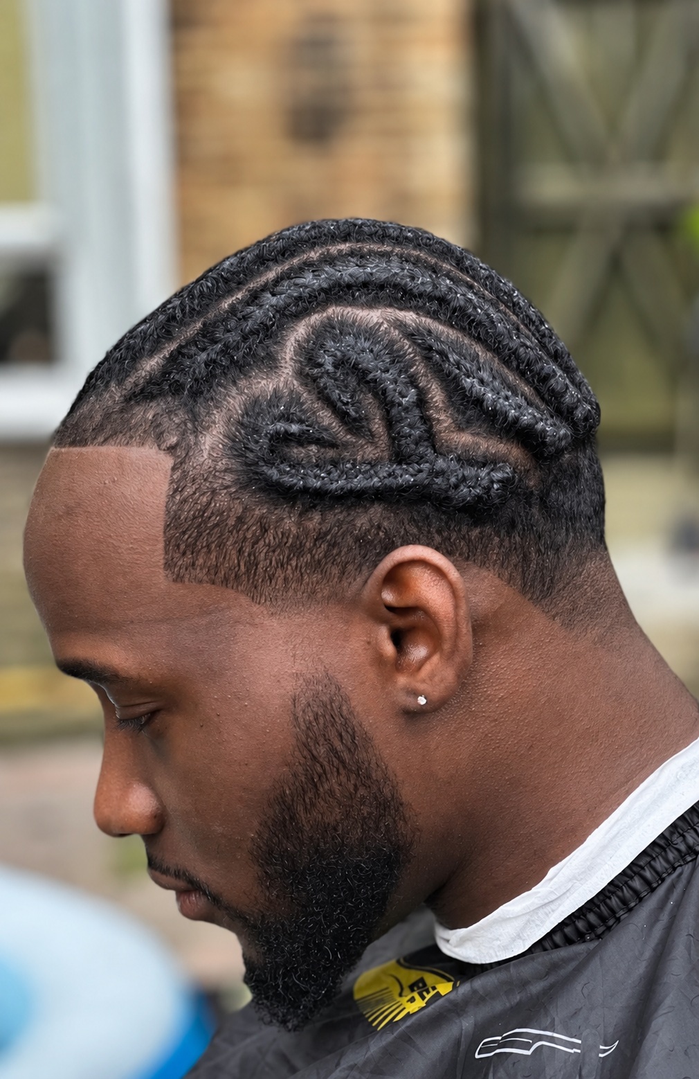 A braided hairstyle with a shaped beard